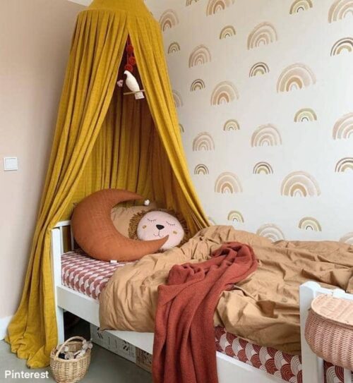 Okergele klamboe boven peuterbed in kinderkamer